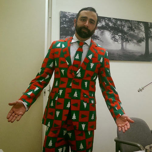 Photo of man wearing a colorful suit with a Christmas tree pattern