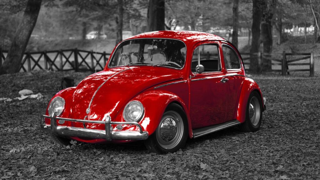 Photo of a red VW Beetle with greyed out background.